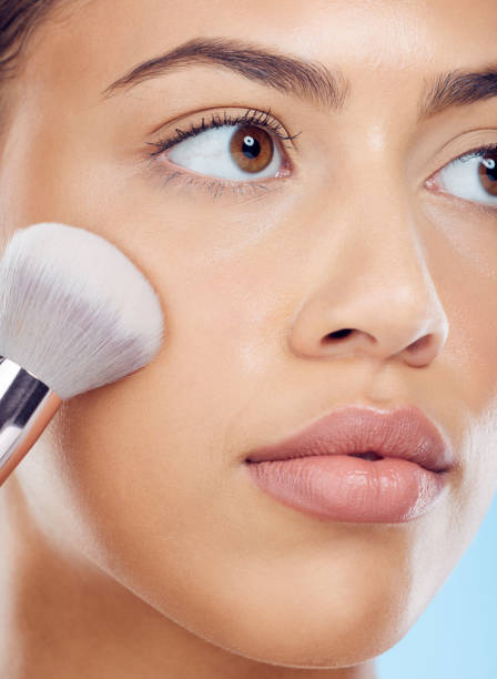 istock Makeup, woman and brush with cosmetics, dermatology and morning routine on blue studio background. Skincare, female and lady tools, salon treatment and luxury for grooming, foundation and smooth skin 1484788090