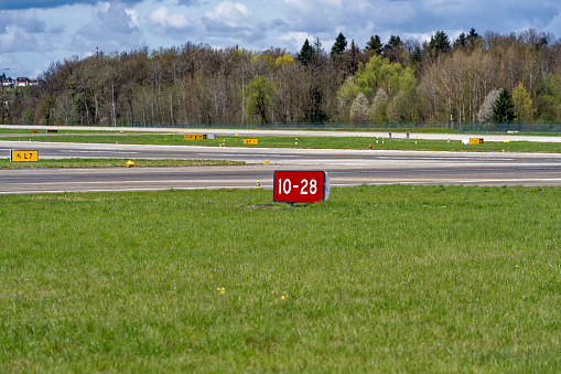 Red sign at runway at Swiss Airport Zürich Kloten on a sunny spring morning. Photo taken April 14th, 2023, Kloten, Canton Zurich, Switzerland.