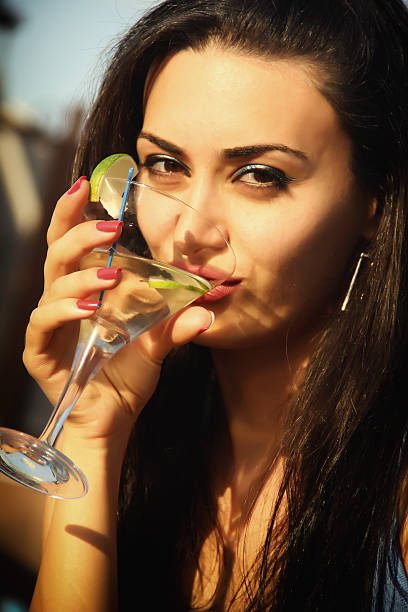 Attractive young girl drinking martini stock photo