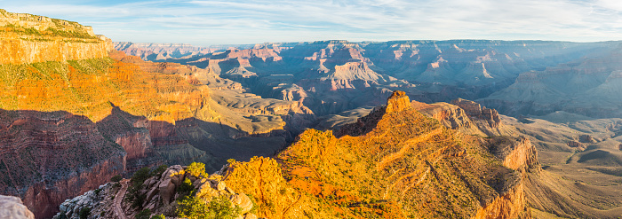 Warm light of sunrise illuminating the golden strata of Cedar Ridge and O’Neill Butte on the South Kaibab Trail down into the Grand Canyon, Arizona, USA.