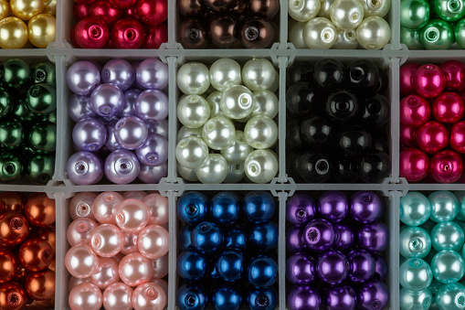 Assorted coloured jewellery beads in a partitioned box