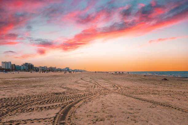 pôr do sol em tons de rosa sobre uma praia em rimini, itália - rimini - fotografias e filmes do acervo