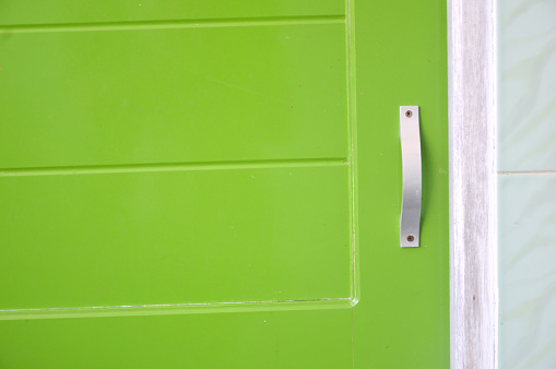 Two bronze padlocks on green metal shutters