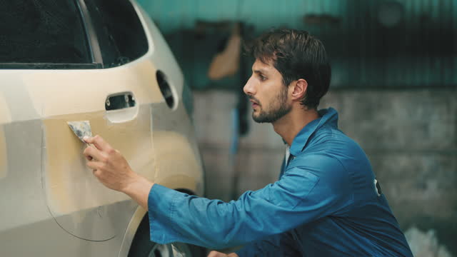 Mechanic repairing the car. Repairing a car after an accident in a workshop garage