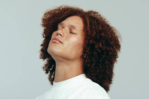 istock Man with a curly afro and freckled face standing in a studio 1484796185