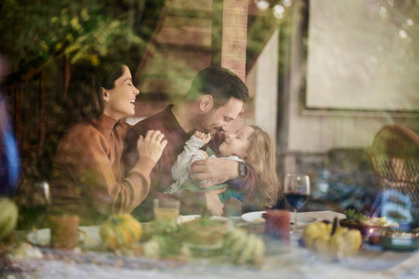 istock Happy parents enjoying with their daughter at dining table. 1484797515