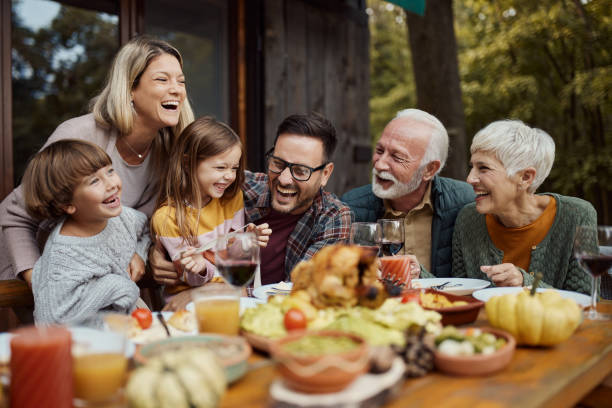 wesoła wielopokoleniowa rodzina bawiąca się podczas lunchu na tarasie. - dining table child grandparent grandchild zdjęcia i obrazy z banku zdjęć