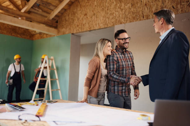 istock Happy couple came to an agreement with architect at construction site. 1484800614