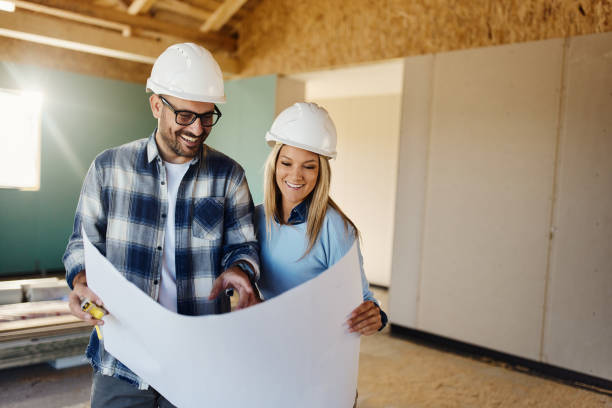 istock Happy couple reading housing plans at construction site. 1484800854