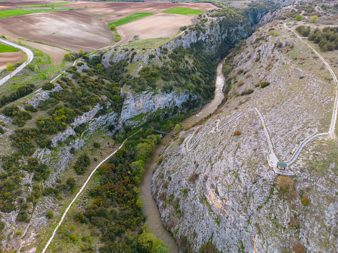 Aerial top view of the Aggitis canyon in Greece offers a breathtaking aerial view of the winding river, steep cliffs, and lush vegetation that make up this natural wonder.