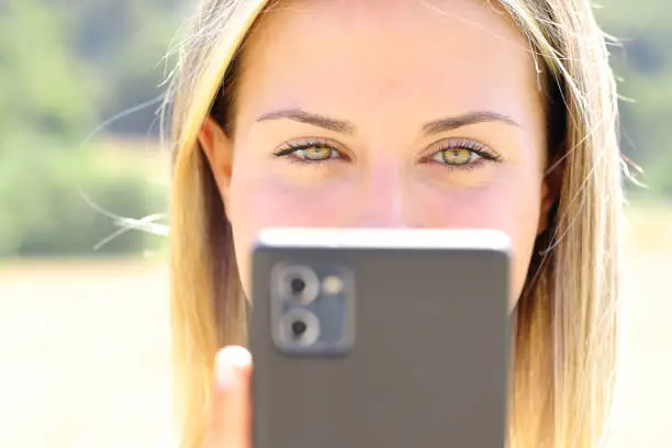 Happy woman with beauty eyes checking phone