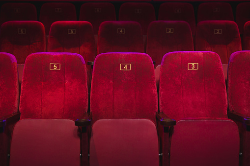 Empty comfortable red seats with numbers in the cinema
