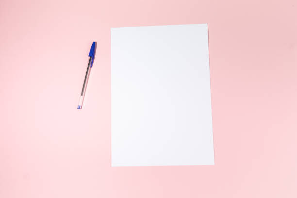 istock empty white paper sheet and a pen on pink background. Mockup 1484803050