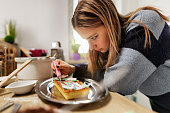 Generation Z teenagers baking and decorating tart cake