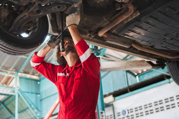 istock Auto mechanic working in garage, Technician man working in auto service with lifted vehicle, Car repair, and maintenance 1484805126