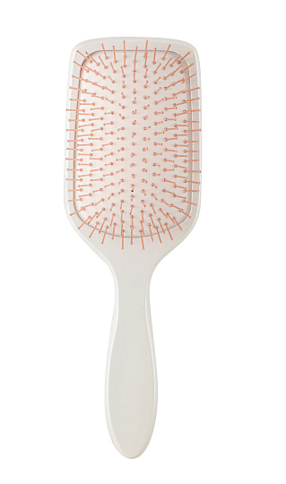 Cream colored hair comb brush with handle and beige bristle, isolated on white background, clipping path, studio shot