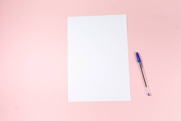 istock empty white paper sheet and a pen on pink background. Mockup 1484806902