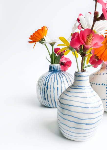 Spring Flowers in Tiny Handmade Ceramic Vases with White Background.