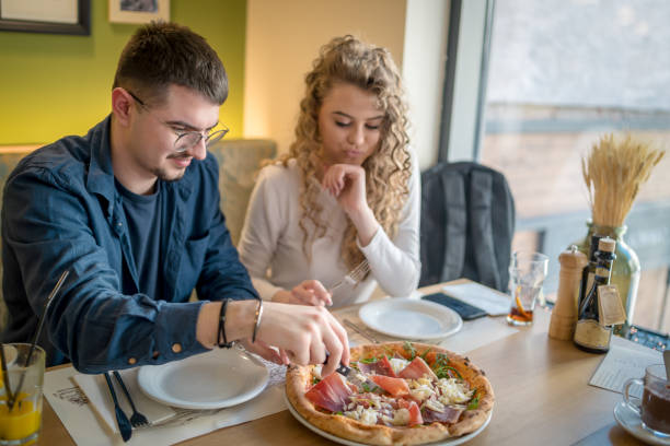 istock Happy smiling couple having fun while eating pizza 1484816544