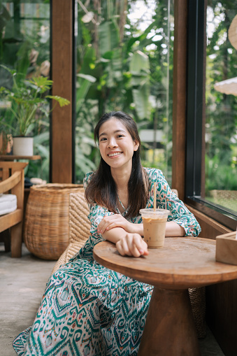 Relaxing beautiful asian Asian cafe hopper enjoy nature and good coffee green garden background