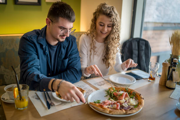 istock Happy smiling couple having fun while eating pizza 1484816826