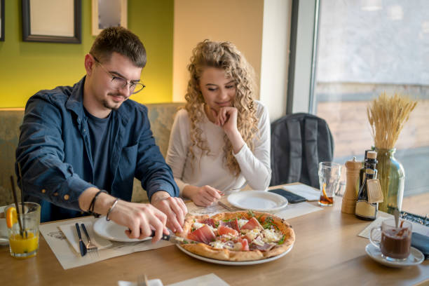 istock Happy smiling couple having fun while eating pizza 1484816874