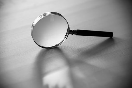 Close up image of daylight shine through clear circular convex lens with refection and refraction of light and cast artistic oval shape of shadow.