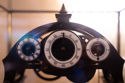 Antique wind-up clock with three dials in vintage style.