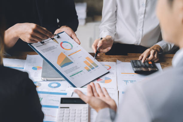 istock Teamwork process, Business team using a calculator to calculate the numbers of statistic business profits growth rate on documents graph data, desk in the office. 1484822498