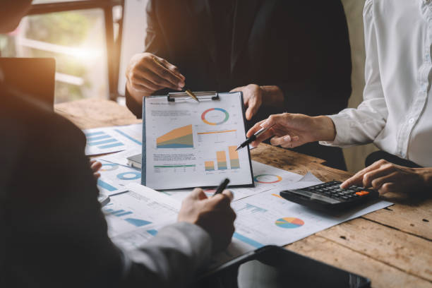istock Teamwork process, Business team using a calculator to calculate the numbers of statistic business profits growth rate on documents graph data, desk in the office. 1484822504