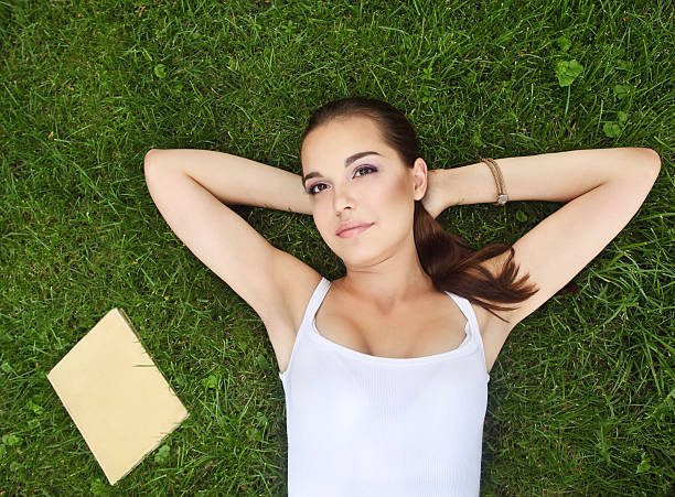 istock Beautiful young girl lying on the grass 148482542