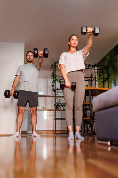 istock Couple working out at home lifting weights 1484825451