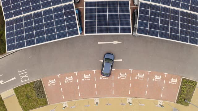 4K aerial footage directly above an electric vehicle parking in an electric car charging space