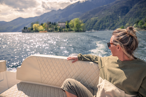 Woman on vacation enjoys a boat ride o a lake
