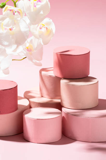 istock Abstract giving concept. Round gift boxes with orchid flower on pink background. 1484828355