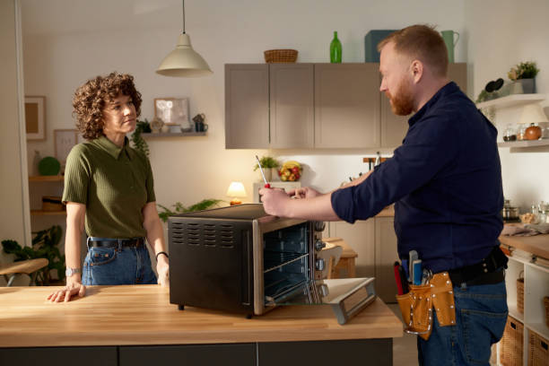 istock Man repairing broken microwave at home 1484829751
