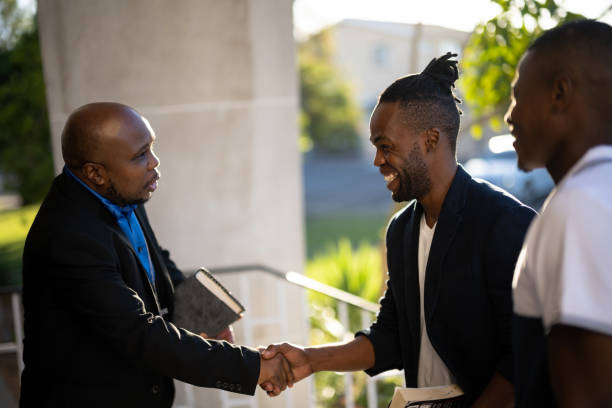 istock Pastor welcomes smiling young man into Church 1484833675