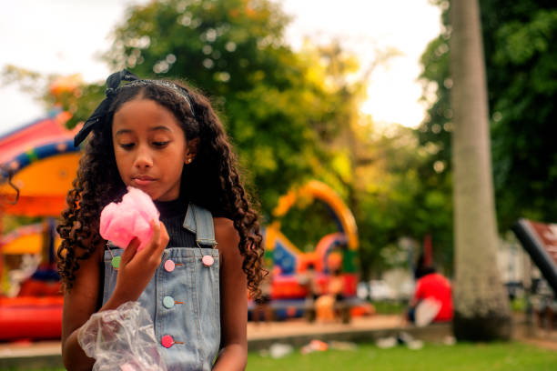 Girl eating cotton candy in pubic garden
