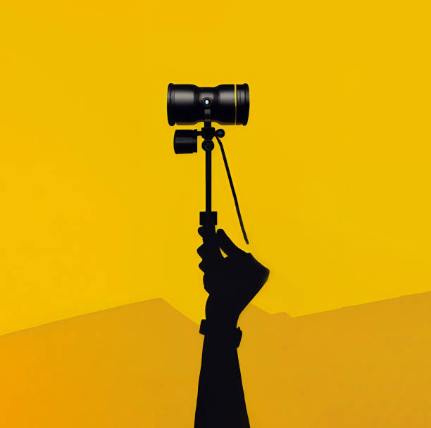 istock Hand holding camera tripod on yellow background. 1484834968