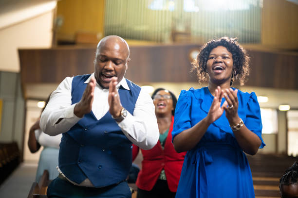 Couple clapping singing and dancing in church Multi-generation family and congregation enjoying church service black gospel church stock pictures, royalty-free photos & images