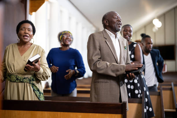 Senior member of congregation singing in church Multi-generation family and congregation enjoying church service black gospel church stock pictures, royalty-free photos & images