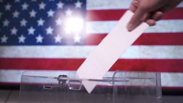A man puts his ballot into the ballot box in the US presidential election