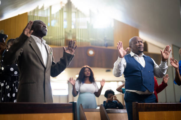 istock Beautiful sunlight through window as congregation prays in church 1484840469