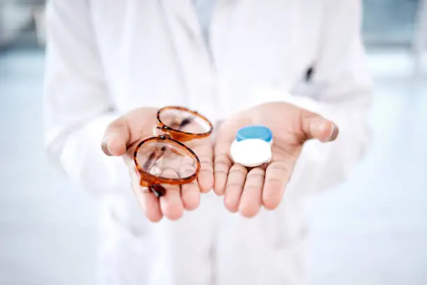 Photo of Eye care, choice with glasses or contact lens in hands, closeup and vision with healthcare for eyes. Prescription lenses, person with frame and plastic container, optometry with optician and health