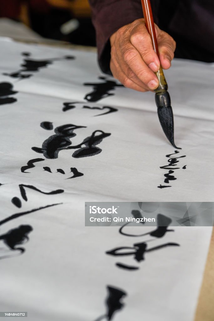 An old calligrapher is writing and creating calligraphy works. Translation: It rains on the pond with light thunder outside Liuwai, and the sound of r Chinese Script Stock Photo