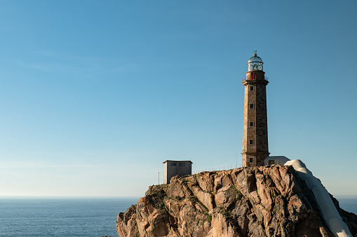 Lighthouse lighting equipment at top of illuminated glass tower as warning to sailors, Sauzon harbour, Belle Ile, Brittany, northwest France