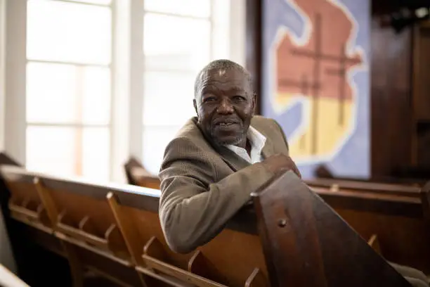 Photo of Portrait of senior man sitting in church