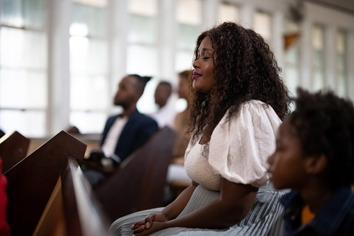 Side view woman with eyes closed praying in church