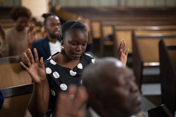 istock Side view young woman with eyes closed and hands raised in prayer 1484842414