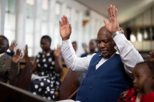 istock Side view man with hands raised and eyes closed in prayer 1484842520